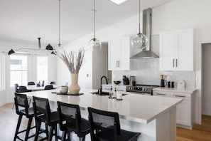 Open concept kitchen with stainless steel appliances, breakfast bar island seating, tons of natural light, and fully stocked with your basic cooking essentials.