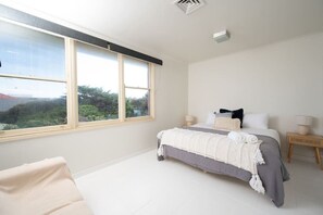 [Bedroom] Spacious bedroom with a soft mattress and pillows and a wide window to get natural light.