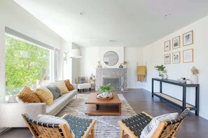 The spacious living area with oversize windows flooding the room with light