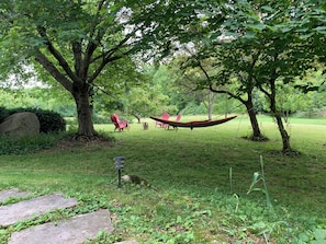 Front porch looks over back fields. Relax in hammocks and chairs with firepit.