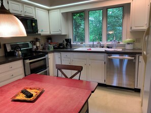 Kitchen with ovens, stove, dishwasher, microwave, fridge, coffees and teas.