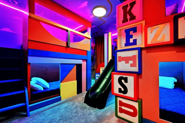 Vibrant Toy-Themed Bunk Room: Slides, Bold Colors & Fun Spaces!