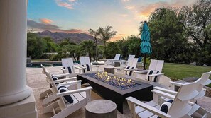 Fire pit patio with Adirondack chairs, scenic mountain views, and twilight glow.