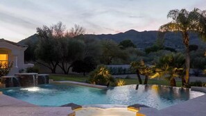 Serene infinity pool with cascading waterfalls and stunning mountain views.