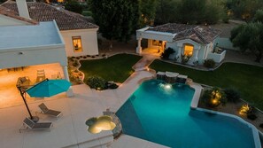 Resort-style backyard with pool, spa, guest house, and lush landscaping.