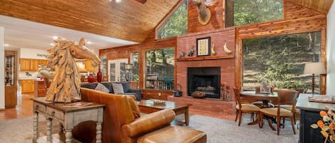 Spacious family room with vaulted ceilings, views of the woods and wildlife,  wonderful fireplace and plenty of room for all your guests to meet up.  There is a Smart TV with Dish cable, a card/ puzzle table, leather sofas and loads of ambiance.