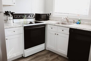 Well stocked kitchen with full size fridge/freezer, four burner electric range, dishwasher, microwave, and more)