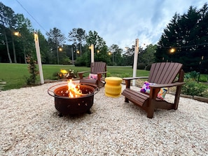 Locally made adirondak chairs; twinkle lights, and fire pit for your use.