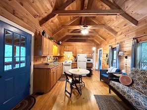 Living and dining space with vaulted ceilings just off the huge screened porch