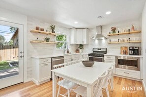 Kitchen with high-end range, dishwasher, refrigerator, and microwave