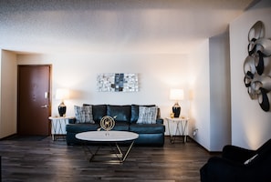 Spacious living room with modern decor and new grey leather sofa and love seat. 