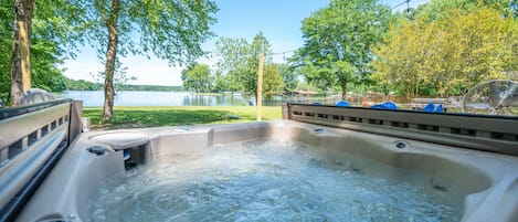 The hot tub overlooks this gorgeous lake view.  Relax in the hot tub while watching the sunset or while enjoying the company of those at the fire-pit or grill. 