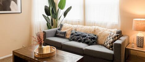 Our stylish & cozy living room comes w/ a wooden coffee table, lamp & couch