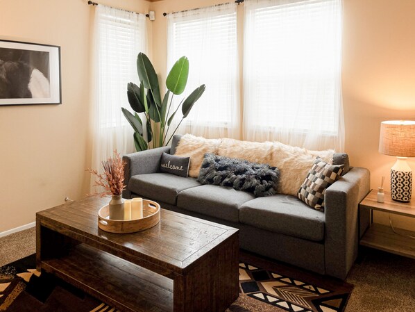 Our stylish & cozy living room comes w/ a wooden coffee table, lamp & couch