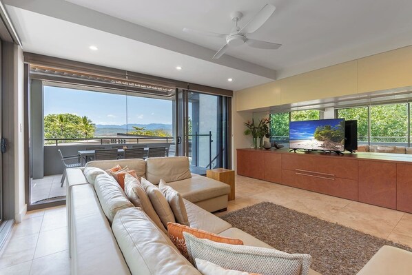 An L-shaped lounge invites you to kick back and relax in front of the Smart TV while enjoying sprawling mountain views through wall-to-wall sliding doors. 
