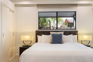 The first bedroom is a modern respite with a king-sized bed and built-in robes for your belongings