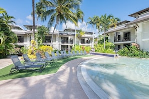 Dive into tropical vibes and endless relaxation by the shimmering pool, surrounded by lush greenery.