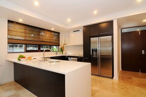 An air-conditioned kitchen comes fully equipped for meals at home with modern appliances and cooking utensils
