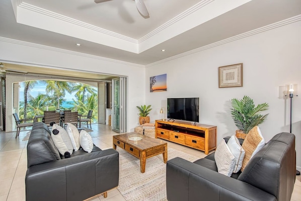 The living area is stylishly appointed with leather lounges and a Smart TV.