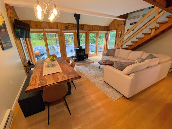 Main living area with dining table, sectional, fireplace and lots of windows!