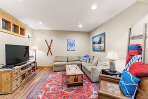 Spacious first floor living room with flat screen TV and ample seating.