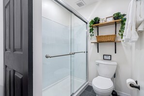 The cute bathroom has a spacious shower.