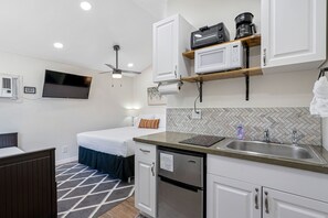 The space features a pull-out daybed, queen bed, bathroom, and kitchen.