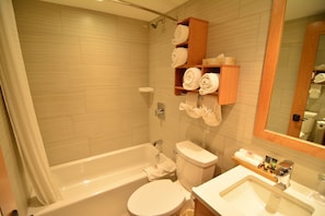 The spacious and bright bathroom features a lovely shower-tub combination.