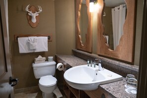 Spacious bathroom with soaker / shower tub & warm wood touches.