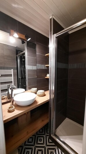Salle d'eau avec douche et radiateur sèche serviettes 