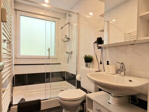 Modernes Bad mit Stehdusche, Waschbecken und Toilette – funktional & hell.