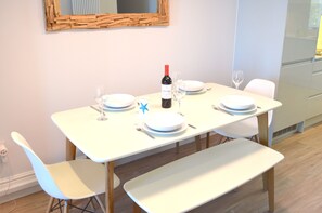 Dining area with new table, chairs and benches. Ample crockery and glassware