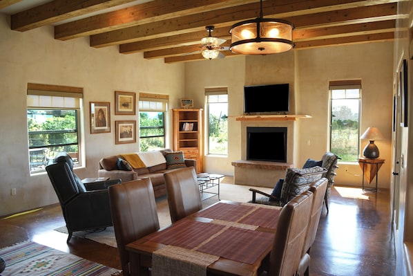 Dining area to warm inviting living room and flat large flatscreen steam TV.