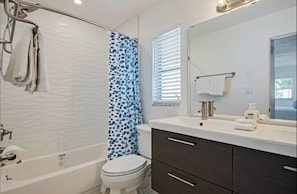 Tub/shower combo with pull down showerhead. Shampoo, conditioner and body wash .