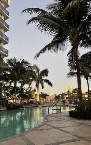 Resort style pool with lounge chairs and cabanas
