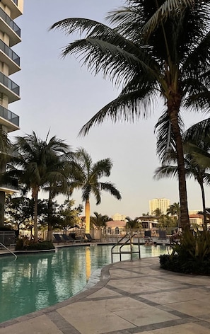 Resort style pool with lounge chairs and cabanas