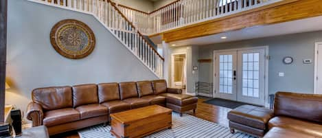 Welcome to our spacious living room! Relax on the plush leather couch in our airy living room, framed by stunning vaulted ceilings.