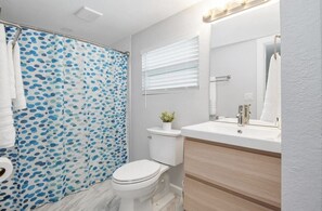 Spacious bathroom with a tub. Shampoo, body wash and conditioner 