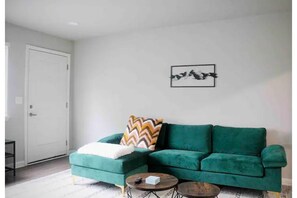 Velvet L-shaped couch near the back entrance 