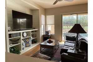 Family room with 75 inch TV and oversize leather couch and chair/ottomen