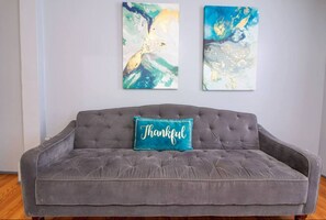 This room features a comfortable queen bed, a spacious wardrobe for your belongings, a TV for your entertainment, and a cozy sofa.