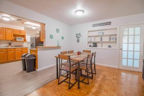 Dining room, wall with shelves for decoration, access to the kitchen and main access door