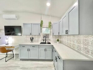 This unit features a kitchen with spacious cabinets that provide ample storage, perfect for keeping everything organized. The open layout allows for a comfortable flow, making it ideal for cooking and socializing.
