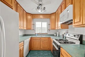 Full kitchen with stove, microwave, dishwasher and refrigerator.