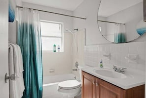 Spacious bathroom with a tub. Shampoo, body wash and conditioner provided