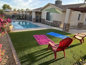 Large turf area poolside for lounging