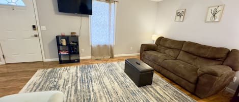 Open Living Room with Large Couch, Rocking Chair and Smart TV