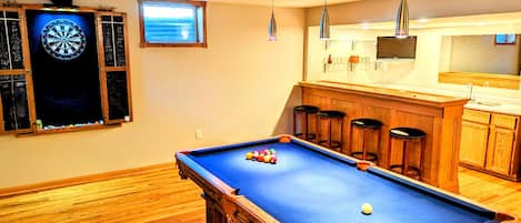 Game room on lower level w/ pool table, dart board, Smart TV, & wet bar.