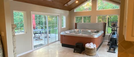 Inviting hot tub overlooking patio with BBQ, fire pit and outside seating.