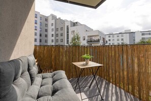 Furnished balcony with green surroundings. 